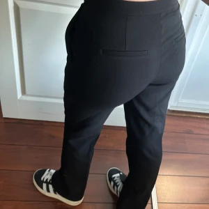 Kostymbyxor  - Säljer dessa eleganta svarta kostymbyxor med slits nertill från h&m, använda en gång, storlek 40