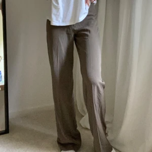 Bruna vida kostymbyxor  - Säljer ett par bruna kostymbyxor i storlek 36 som har en lös och avslappnad passform med vida, knappt använda. Skriv för fler bilder:). 