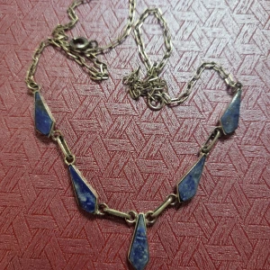Silverhalsband med blå stenar - Säljer ett snyggt silverhalsband med fem blå stenar i geometriska former. Kedjan är tunn och elegant, perfekt för både vardag och fest. Stenarna har en djup blå färg som verkligen poppar mot silvermetallen. Ett unikt smycke för den som vill sticka ut!