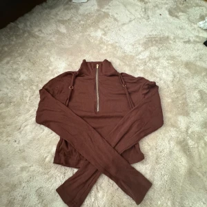 Brun ribbad tröja med dragkedja - Säljer en snygg brun ribbad tröja med dragkedja framtill. passar storlek S-M