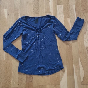 Mörkblå tröja med stjärnmönster från H&M - Säljer en superfin mörkblå pyjamastopp från H&M, storlek XS, med ett stjärnmönster. Tröjan har långa ärmar och en snygg snörning framtill. Köparen står för frakten 💕