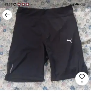 Säljer ett par svarta träningsshorts från Puma. De är perfekta för gymmet eller löprundan. Shortsen har en tight passform och är gjorda i ett bekvämt material som andas. Puma-loggan syns tydligt på ena benet. Perfekta för dig som vill ha stil och funktion i ett!