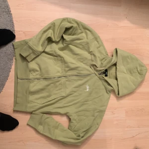 Stussy grön zip tröja - Väldigt stilig o streetwear, luvan är ganska stor och mysig, materialet är jätte skönt, går att pruta, nypris tror ca 1600 