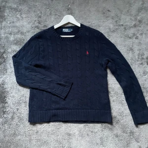 Ralph Lauren Cableknit - Säljer denna Ralph lauren tröjan, Den är i bra skick och marinblå/svart med röd logga, pris kan diskuteras vid snabb affär. Nypris 2500kr