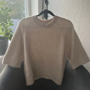& Other Stories tröja - Beige stickad t-shirt i alpacka från & Other Stories i storlek S. Den är i fint skick och har inga defekter. Nypris är 790 kr.