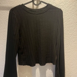 Svart tröja - Svart lång ärmad crop top. Fick den av en kompis, ingen lapp finns men är säker på att storleken är M, jätte skönt och lent  material.