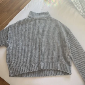 Grå stickad kaphall tröja!🤍 - Säljer en supermysig grå stickad kaphal. Perfekt för kyliga dagar med sin ribbade design och långa ärmar. Tröjan har en croppad passform som ger en modern look. Perfekt för både höst och vinter!Använd 1 gång och är tvättad.Storlek 170/S .Super mysig me ett linne under också!orginal pris är 350 men vi kan diskutera!