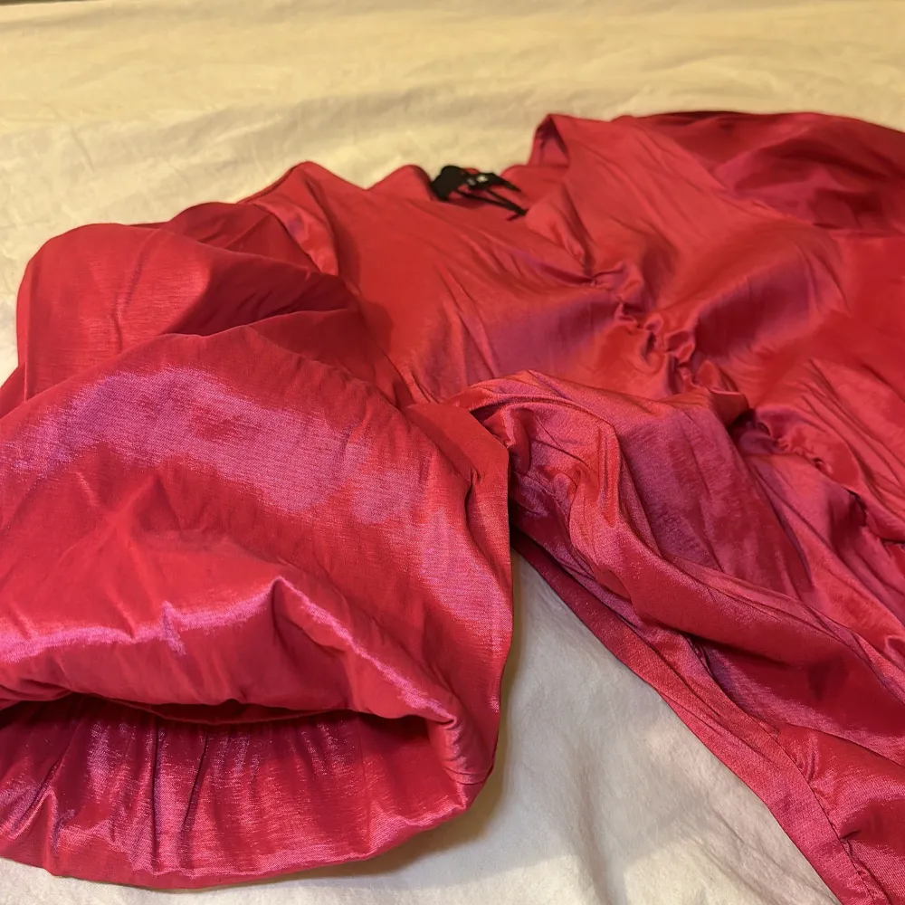 Säljer en oanvänd snygg rosa blus från BIKBOK med korta puffärmar och rynkdetaljer framtill, diskret dragkedja på sidan. Perfekt för att liva upp garderoben med lite färg!. Yläosat.