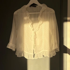 Blus Zara - Super fin vit blus med trekvart ärmar och volanger från Zara. Passar jättebra att ha över ett linne!🤗Storlek L men om man skulle vilja ha den oversize så passar den M också.💗