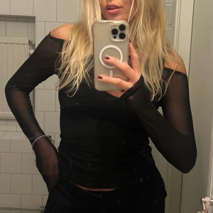 Svart mesh topp - Snygg svart mesh topp med offshoulder-design och långa ärmar. Perfekt för en trendig look💞