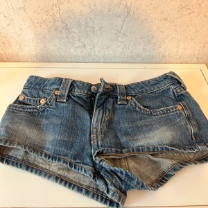 Blå jeansshorts - Jättefina lågmidjade jeansshorts från Weekday, säljer då de tyvärr börjar kännas lite för små och kortare än jag hade velat. Har använts ganska mycket, men är i fint skick. Storlek 25, skulle tippa på att det motsvarar ca. 32