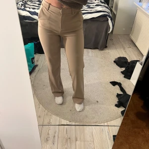 Beige byxor från Vero Moda - Snygga beige byxor från Vero Moda i storlek XS. Byxorna har en rak passform och är stretchiga och supersköna. Har använt ett par gånger men det finns inga fläckar på dom eller slitage🌸
