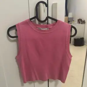 Säljer en söt rosa ärmlös topp från Zara. Den är croppad och har en ribbad kant vid halsen. Perfekt för varma dagar eller som ett lager under en jacka.