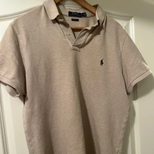 Beige pikétröja från Ralph Lauren - Säljer en riktigt snygg beige pikétröja från Ralph Lauren. Tar inga returer, bör av er vid intresse.