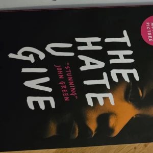 The Hate U Give - Boken 'The Hate U Give' med ett omslag som visar en del av ett ansikte i mörka toner. Texten är i vita och rosa bokstäver. En stark och tankeväckande berättelse som har fått mycket beröm.