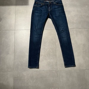 Mörkblå nudie jeans  - Snygga mörkblå jeans med klassisk femficksdesign och orange sömmar. Byxorna är från nudie jeans och är i modellen thigt terry (slim fit). Jeansen är i mycket fint skicka och kostar 2000kr nya men jag säljer de för 349kr hör av er vid fler frågor eller bilder!