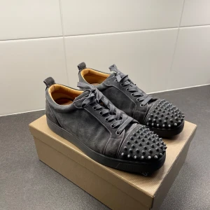 Svarta sneakers med nitar - Christian Louboutin skor med spikar i populär modell. Använd och det finns små spår av användning, men i övrigt i fint skick. Originalkartong, dammpåse, remmar och skogaffel kommer också med.  Om du har några frågor, fråga gärna!  Priset kan fortfarande förhandlas
