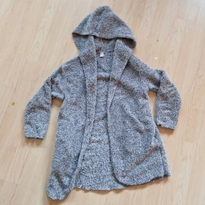 Grå teddyjacka med huva från Shein - Mysig grå teddyjacka från Shein med huva. Perfekt för kyliga dagar, denna jacka är både bekväm och stilren. Den har en lös passform och är tillverkad i ett fluffigt material som håller dig varm. Storlek 11år eller XXS