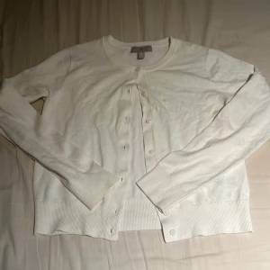 Vit kofta från H&M - Säljer en stilren vit kofta från H&M i storlek S. Koftan har långa ärmar och knappar framtill, perfekt för en enkel och klassisk look. Passar bra till både vardag och mer uppklädda tillfällen.