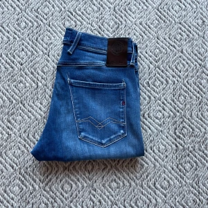 Replay jeans Anbass - Säljer ett par snygga blå jeans från Replay i modellen anbass. Jeansen är i väldigt bra skick bortsett från att lappen på insidan är avklippt. Storleken på Jeansen är W30/L30. Vid minsta fråga eller fundering är det bara att höra av sig!👍😁