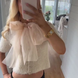 Vit kofta med stor rosett från Zara - Säljer en söt vit kofta från Zara med en stor, elegant rosett framtill. Koftan har trekvartsärmar och knappar längs framsidan. Den är liten i storleken så den passar en som vanligtvis  har s/xs också❣️den är i helt nytt skick, aldrig använt ❣️inte min bild. Bara och höra av sig om egna bilder eller om du fundera på något🙌