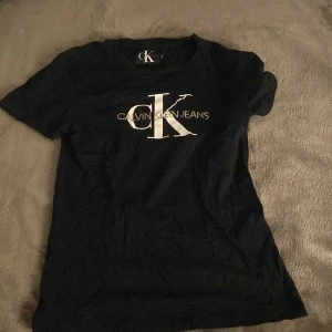 Svart t-shirt från Calvin Klein Jeans - Snygg svart t-shirt från Calvin Klein Jeans med det ikoniska CK-logotypen tryckt i vitt på framsidan. Nästan aldrig använd 