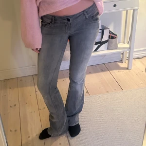 Lågmidjade bootcut jeans - Snygga grå bootcut jeans med låg midja. Har en dragkedja fram på ena sidan, jättefin detalj!❤️midjemått: 38cm, innerbenslängd: 86cm