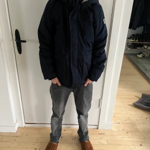 Mörkblå barn vinterjacka med foder - Säljer en mörkblå barn vinterjacka med mysigt foder. Den har en dragkedja framtill och praktiska fickor. Perfekt för kalla dagar och håller dig varm och bekväm. Jackan har en stilren design och passar till det mesta. Perfekt för vintern! ❄️