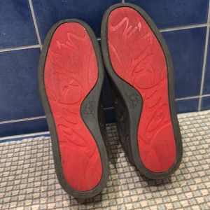 Loubs - Snygga grå mockaskor med ikonisk röd sula och snörning. Perfekta för en stilren look. Box och kvitto medföljs