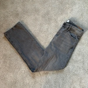 Gråa Jack & jones jeans - Säljer ett par helt sprillans nya snygga gråa jeans i den populära chriis modellen från jack & jones. Nypris ca 900kr. Först till kvarn!