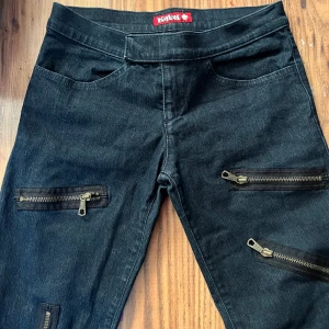 Y2k byxor - SÅ snygga jeans med dragkedjor som detaljer!! Köpta secondhand, kommer inte ihåg om det var på plick eller annan. Aldrig använda av mig! Hör av er vid frågor och vid intresse så diskuterar vi frakt!