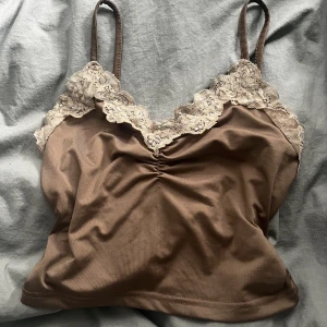 brunt linne med spets - linne med stretchigt material. Sitter lite tajt på mig som har S-M