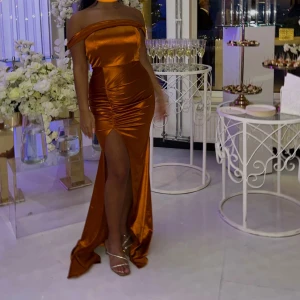 Festklänning  - Säljer denna festklänning som endast använd 1 gång. Kvaliteten är super fin, färgen i orange/brunt i satin. 