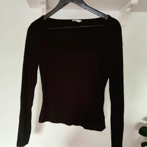 Svart, tight tröja - Fint ribbad, svart tröja med rund linning och lite kortare midjelängd.