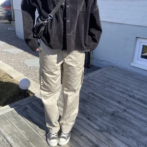 Beiga cargobyxor - Säljer mina älskade cargo byxor. Dom är i storlek M men sitter snyggt oversized på mig som är XS/S och är hellånga på mig 170 cm. Har en liten bläck fläck på benet men annars finns inga defekter💕