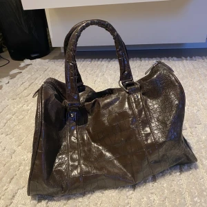 Väska - En jättefin, brun medelstor väska. Har några mindre slitningar uppe vid dragkedjan som syns på andra bilden men inget jag tycker man lägger märke till. Skriv gärna om ni har frågor!