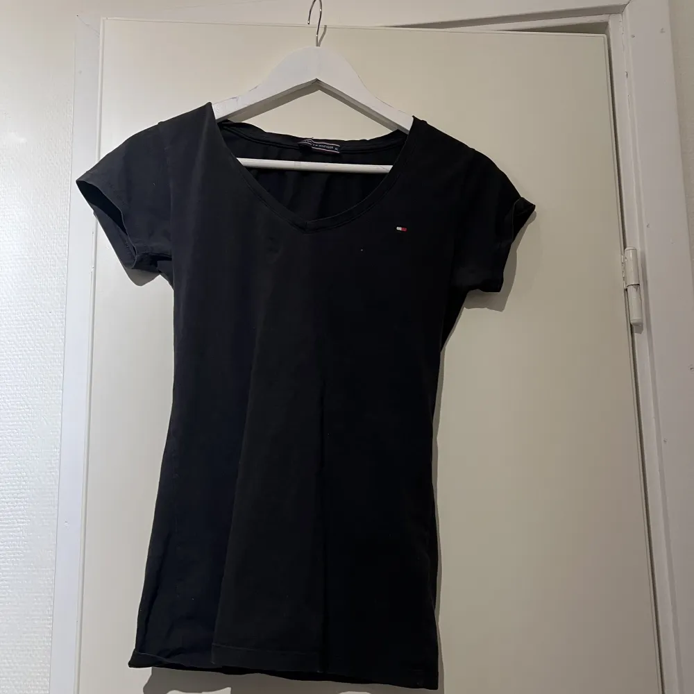En svart loggo tishirt från Tommy Hilfiger, storlek L men mer som en S . T-shirts.