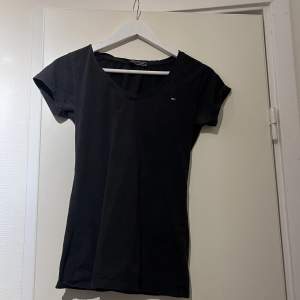 En svart loggo tishirt från Tommy Hilfiger, storlek L men mer som en S 
