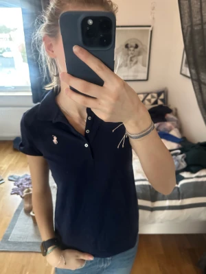 Ralp lauren tröja - Fin marinblå polotröja från Ralp lauren! St 16/XL barnstorlek vilket passar mig som är en xs i damkläder. 