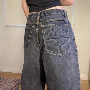 Svarta baggy jeans med tryck på ena bakfickan. Köpta här på Plick men säljer vidare för att de inte passade mig. Midjemåttet är runt 80 cm och innerbenet runt 75 cm. Obs! Bilderna är från förra säljaren. Startpris 100kr