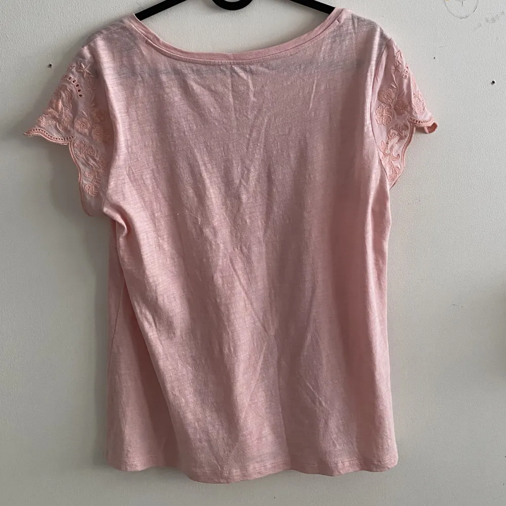 Säljer denna jätte fina ljus rosa T-shirten💞 Det är bomulls material och det är jätte skönt. Den har en fin blomm detalj runt om nacken som går ut i båda armarna🌸 Tröjan har testats av mig en gång Skriv om ni vill ha mera information❤️. T-shirts.