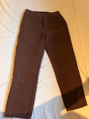 Sällsynta ”Quasi” bruna skatebyxor  - Jättefina, ovanliga skatebyxor. aldrig skejtade i, raka i modellen.  Mått Ben:100cm Innerbenlängd:73cm Benöppning: 22cm Midja: 41cm  Lycka till!