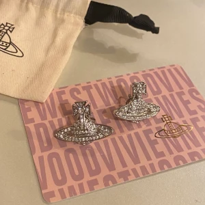 Vivienne Westwood örhängen  - Helt nya vivienne westwood örhängen,   Mini Bass Earrings, bild två visar hur de sitter på örat 