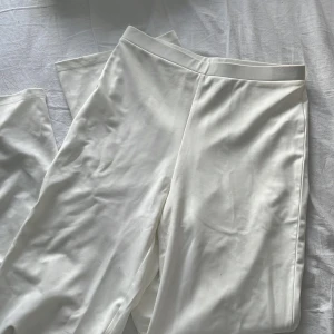 Vita kostymbyxor  - Vita långa byxor som sitter åt vid låren. Plagget är i L men passar även M.  (Om du vill ha bild med plagget på skriv privat)