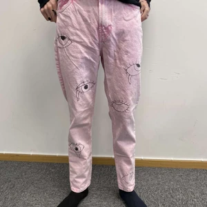 Rosa jeans med målade ögon strl 36 - Byxorna är högmidjade. Ögonen är målade med svart textilfärg.