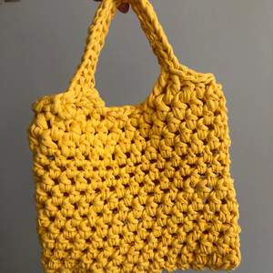 Virkad väska i gul trikå, ca 25x35 cm. Aldrig använd.   Går att beställa i andra färger och storlekar. 