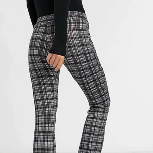 Byxor - Utsvängda byxor strl 38 från ASOS. Grå/svartrutig med resår i midjan. Nyskick 