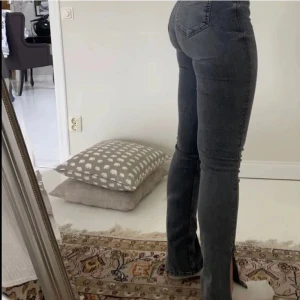 Gråa Zara jeans med slits - Jätte fina gråa jeans från Zara med slits på utsidan av benet, jag säljer dom för 200kr+ frakt i storlek 34