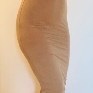 Beige/ljusbrun kjol strl S/M - Snygg trendig kjol i naturmaterialet Viskos.  Stretchig och skön på.  Strl S/M.  Oanvänd. 