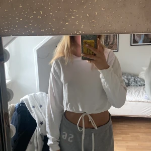 Vit tröja - Vit långärmad tröja med resor i midjan. Kommer från Nelly. Strl XS